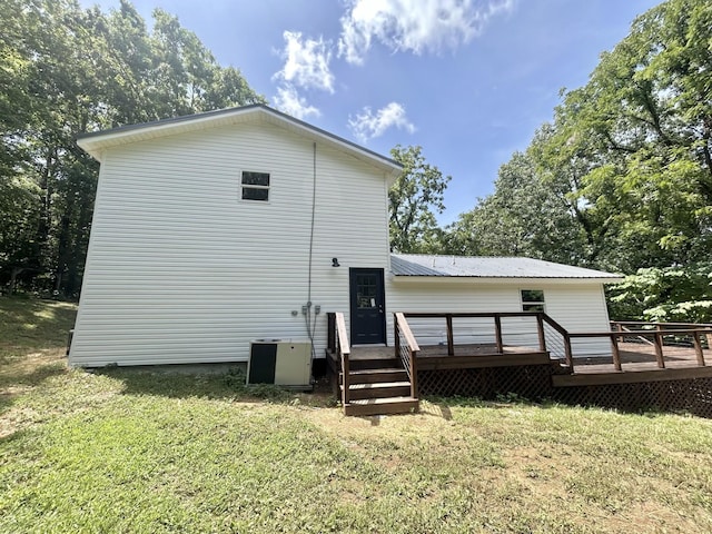 rear view of house with a lawn, central AC unit, and a deck