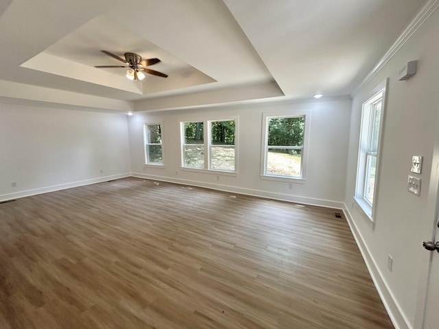 empty room featuring ceiling fan, dark hardwood / wood-style floors, crown molding, and a tray ceiling