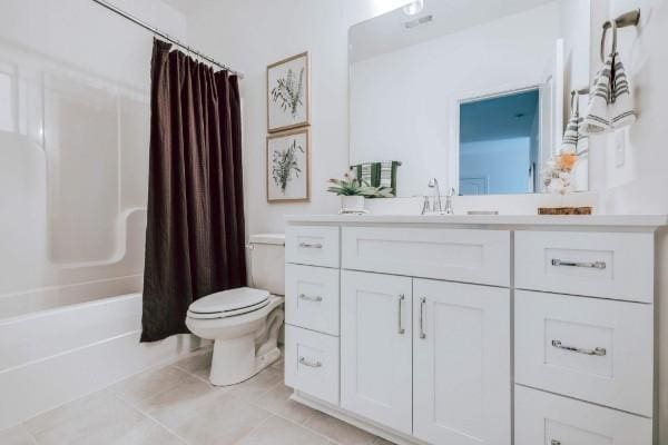 full bathroom with tile patterned flooring, vanity, toilet, and shower / bath combo with shower curtain