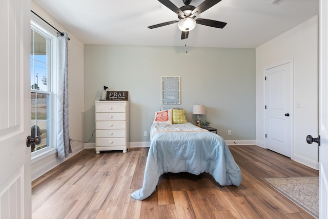 bedroom featuring multiple windows, ceiling fan, and light hardwood / wood-style floors