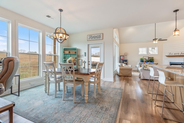 dining room with hardwood / wood-style flooring and ceiling fan with notable chandelier