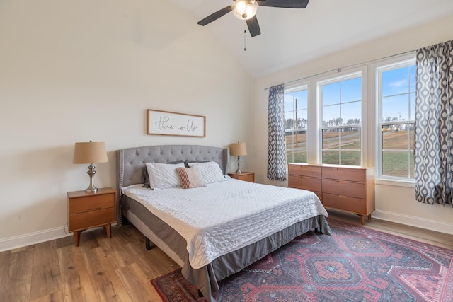 bedroom with hardwood / wood-style floors, ceiling fan, and vaulted ceiling