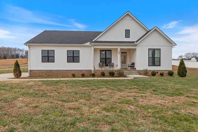 modern farmhouse featuring covered porch and a front yard