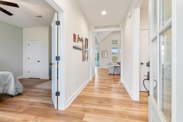 hall featuring vaulted ceiling and light hardwood / wood-style flooring