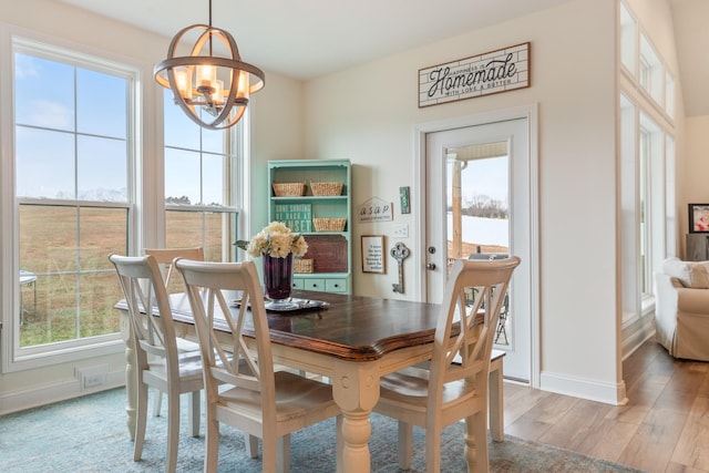 dining space featuring plenty of natural light, a chandelier, and light wood-type flooring