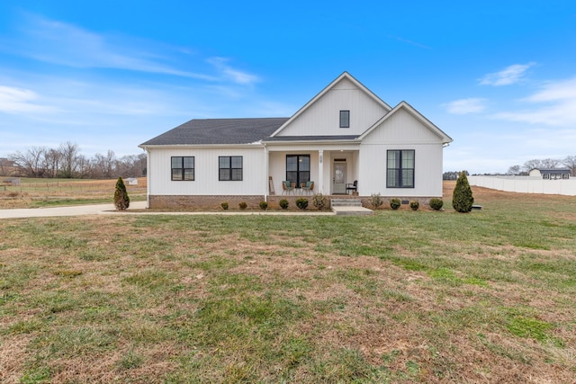 modern farmhouse style home with covered porch and a front lawn