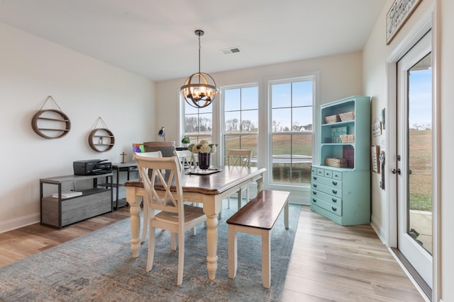 dining room featuring light hardwood / wood-style floors, an inviting chandelier, and a healthy amount of sunlight