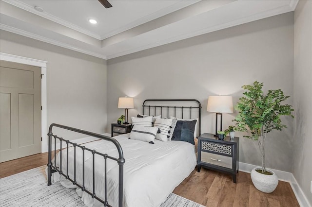 bedroom with hardwood / wood-style floors, ceiling fan, and crown molding