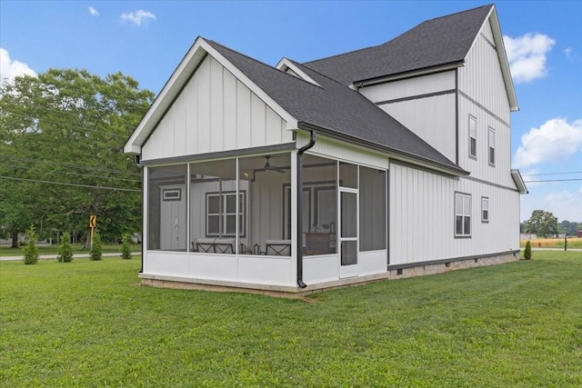 view of side of home with a sunroom and a lawn