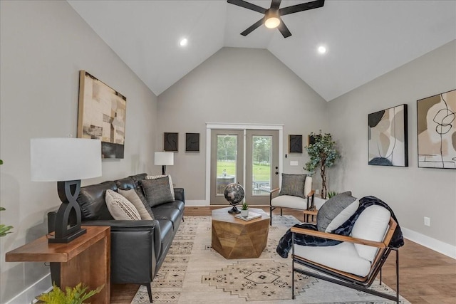 living room featuring ceiling fan, high vaulted ceiling, and light hardwood / wood-style flooring