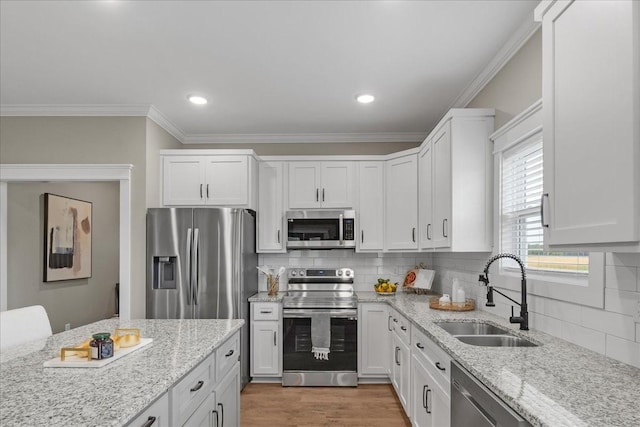 kitchen featuring light stone countertops, sink, white cabinetry, and stainless steel appliances