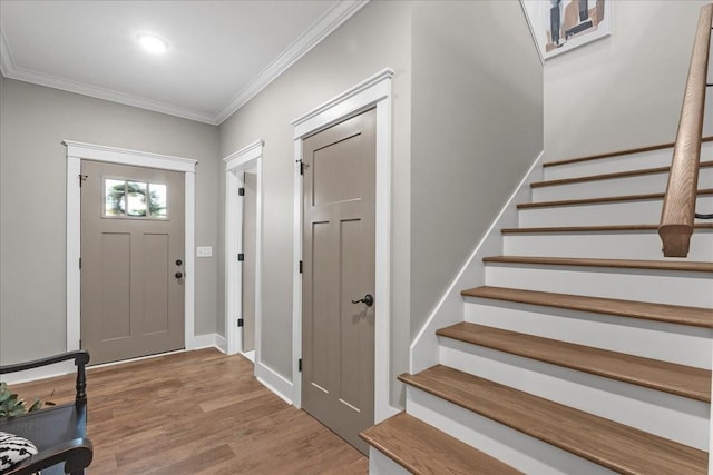 entryway featuring crown molding and light hardwood / wood-style flooring