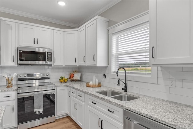 kitchen with backsplash, white cabinetry, sink, and appliances with stainless steel finishes