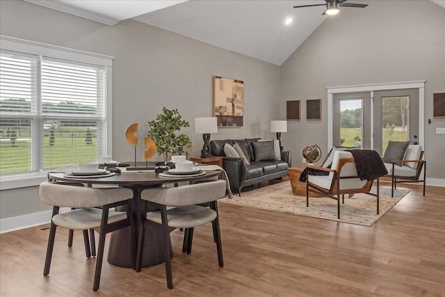 dining area featuring ceiling fan, wood-type flooring, and high vaulted ceiling