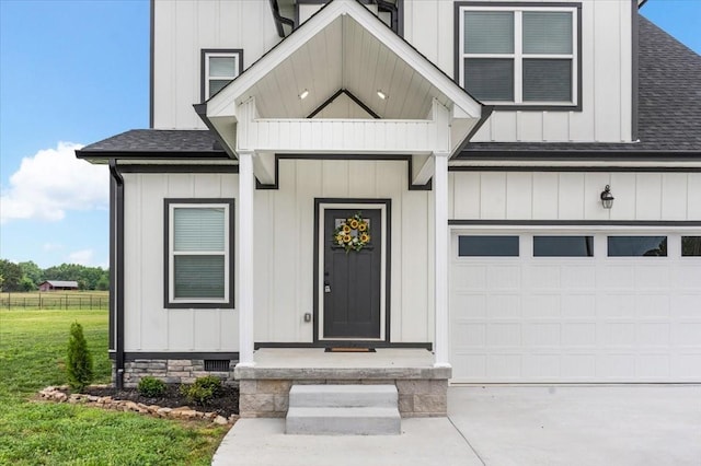 entrance to property featuring a lawn and a garage