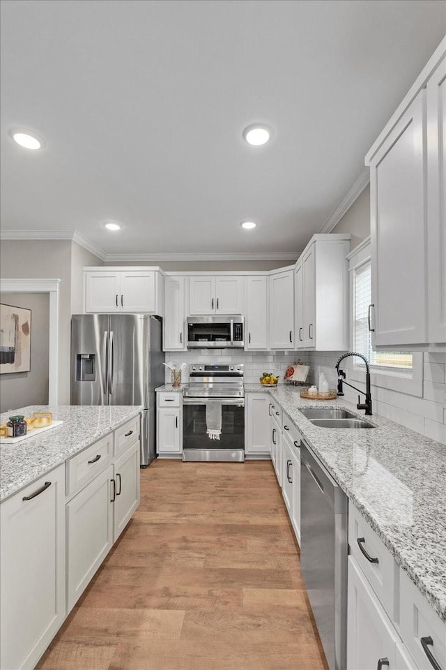 kitchen featuring light stone counters, sink, white cabinets, and appliances with stainless steel finishes