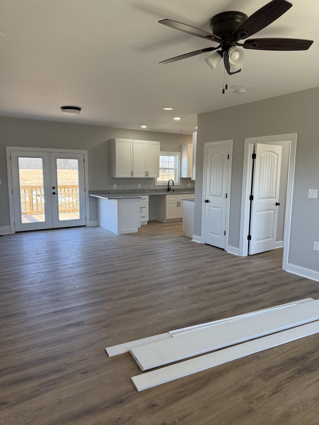 interior space with french doors, ceiling fan, dark wood-type flooring, sink, and white cabinetry