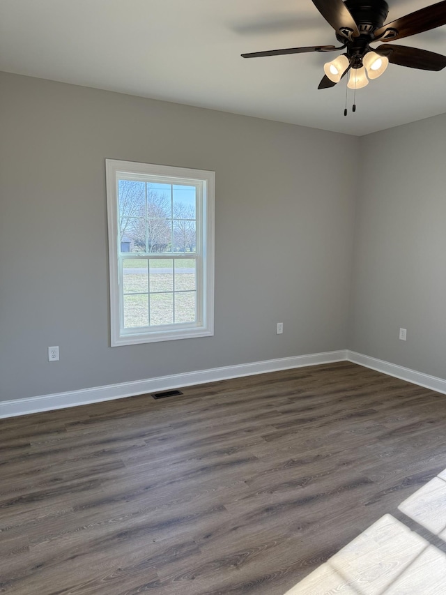 spare room with ceiling fan and dark wood-type flooring