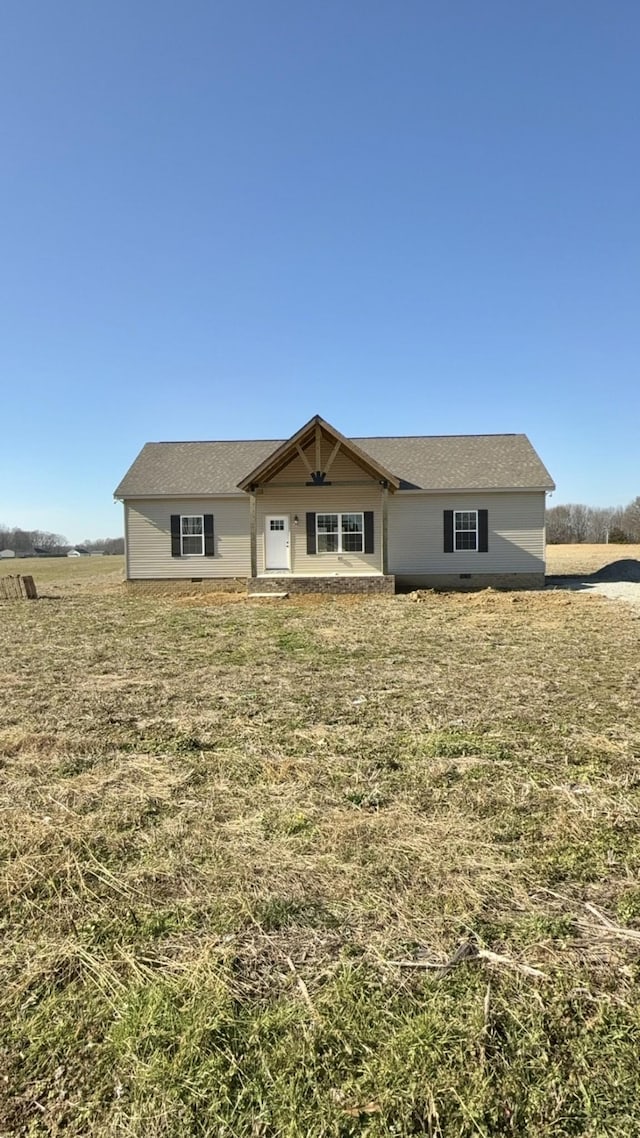 single story home featuring a front lawn and a rural view