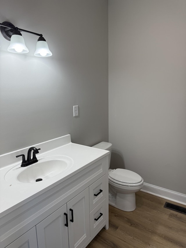 bathroom featuring vanity, wood-type flooring, and toilet