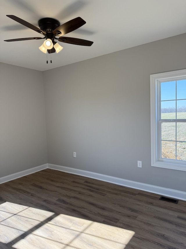 unfurnished room with ceiling fan and dark wood-type flooring