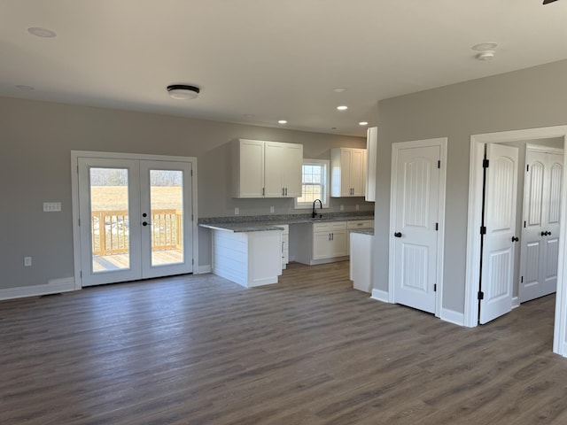 kitchen featuring white cabinetry, sink, french doors, dark hardwood / wood-style floors, and dark stone countertops