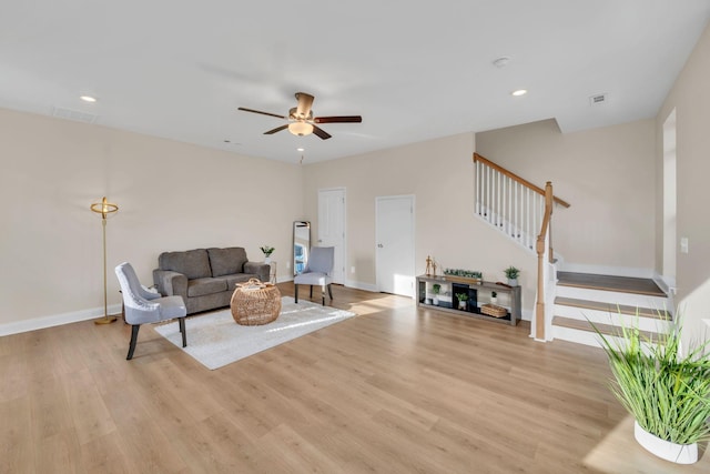 living room with ceiling fan and light hardwood / wood-style flooring