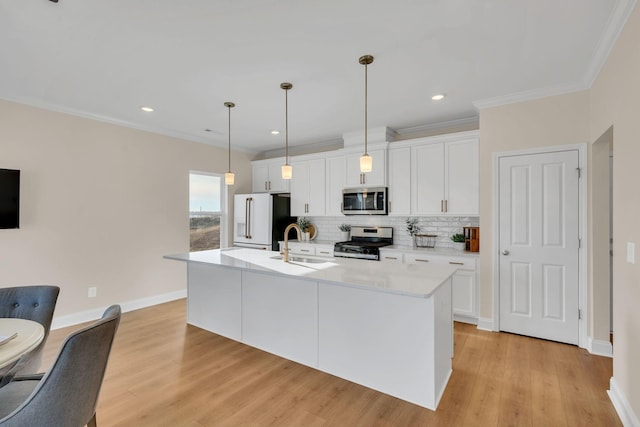 kitchen featuring white cabinetry, hanging light fixtures, backsplash, an island with sink, and appliances with stainless steel finishes