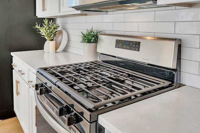 details featuring tasteful backsplash, stainless steel gas stove, and white cabinets