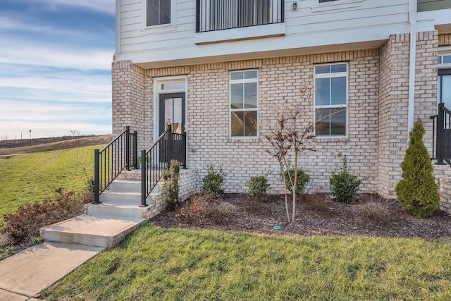 view of exterior entry with a lawn