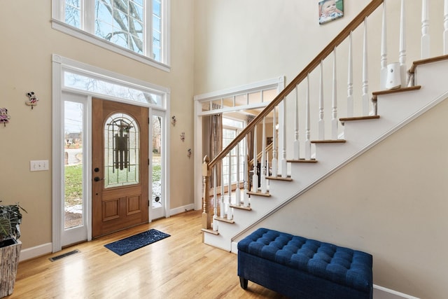 entrance foyer with light hardwood / wood-style floors and a high ceiling