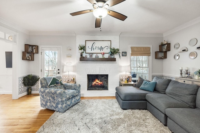 living room with hardwood / wood-style floors, a brick fireplace, and ornamental molding