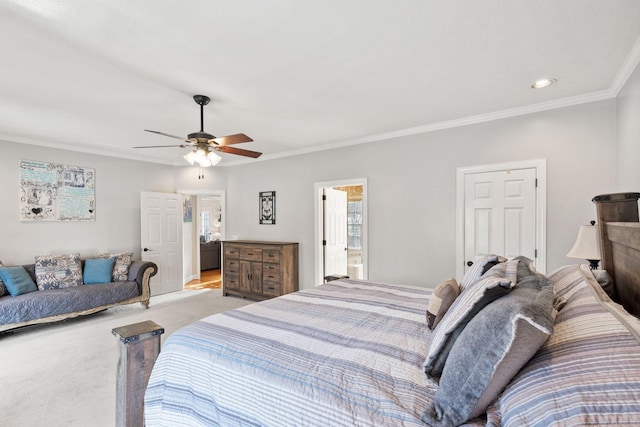 carpeted bedroom featuring ensuite bath, ceiling fan, and ornamental molding