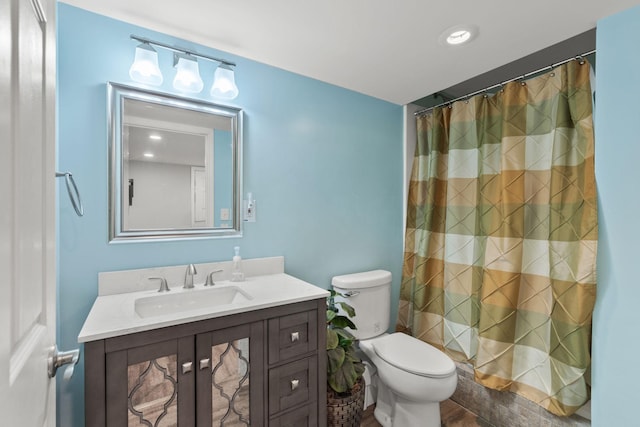 bathroom featuring toilet, hardwood / wood-style flooring, walk in shower, and vanity