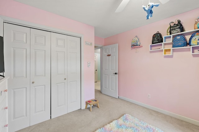 carpeted bedroom featuring ceiling fan and a closet