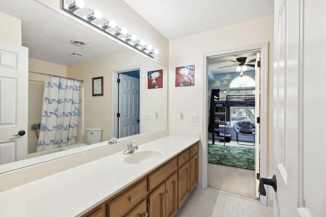 full bathroom featuring shower / tub combo with curtain, tile patterned flooring, ceiling fan, toilet, and vanity