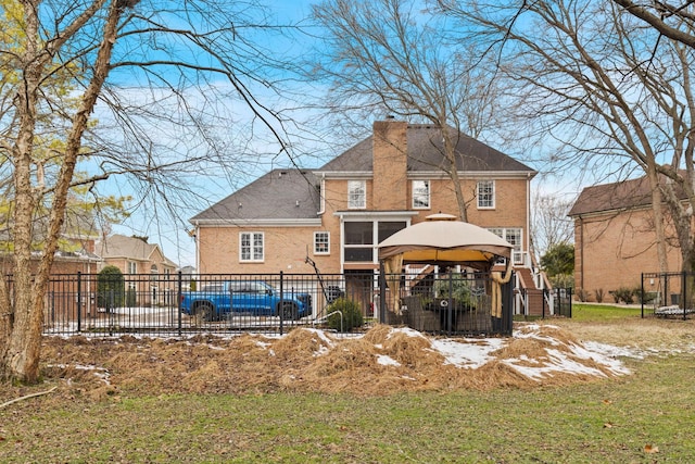 rear view of house featuring a gazebo and a yard