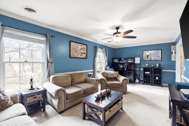 living room featuring ceiling fan, crown molding, and carpet