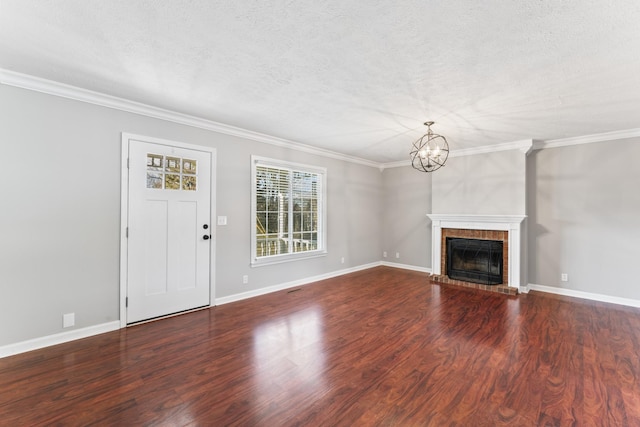 unfurnished living room with ornamental molding, a fireplace, dark wood-type flooring, and a notable chandelier