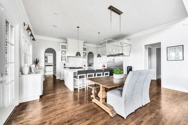 dining area featuring ornamental molding and dark wood-type flooring