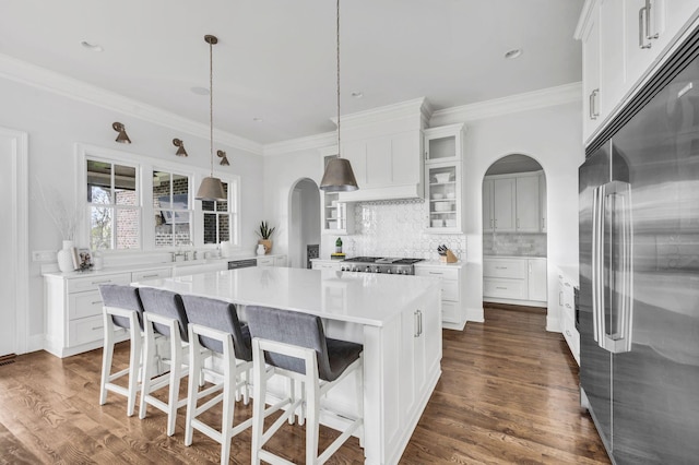 kitchen featuring pendant lighting, white cabinetry, a kitchen island, and built in fridge