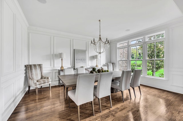 dining area with crown molding, dark hardwood / wood-style flooring, and an inviting chandelier