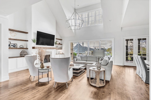 living room featuring hardwood / wood-style flooring, a high ceiling, and a notable chandelier