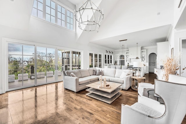 living room with hardwood / wood-style floors, a notable chandelier, and a high ceiling