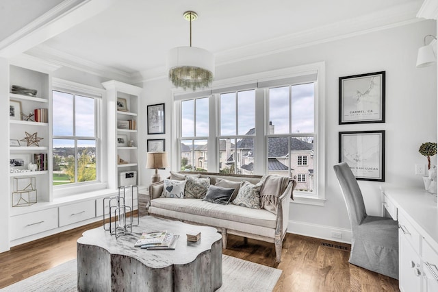 living room with dark hardwood / wood-style floors, ornamental molding, a wealth of natural light, and built in shelves