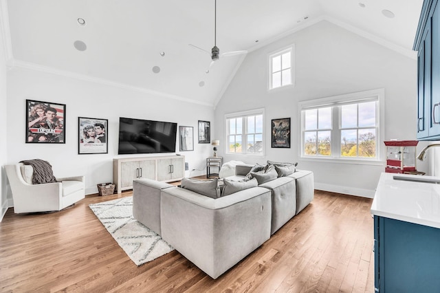 living room with high vaulted ceiling, sink, ceiling fan, ornamental molding, and light hardwood / wood-style floors