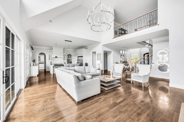 living room with hardwood / wood-style floors, high vaulted ceiling, and a notable chandelier