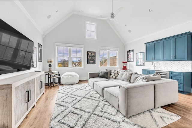 living room with ceiling fan, crown molding, and light wood-type flooring