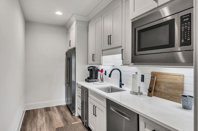 kitchen featuring white cabinetry, sink, stainless steel appliances, dark hardwood / wood-style flooring, and decorative backsplash