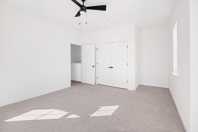 unfurnished bedroom with ceiling fan, light carpet, and a closet